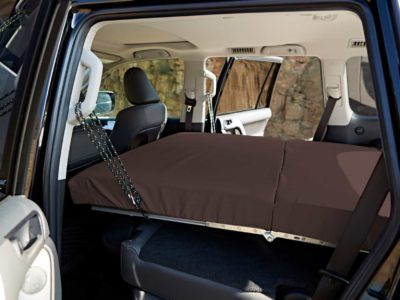 Die aufgeklappte Matratze wird an den Sicherheitsgurten aufgehängt